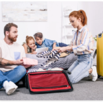 happy-family-packing-luggage-for-trip-in-bedroom-2021-08-31-22-20-43-utc@2x